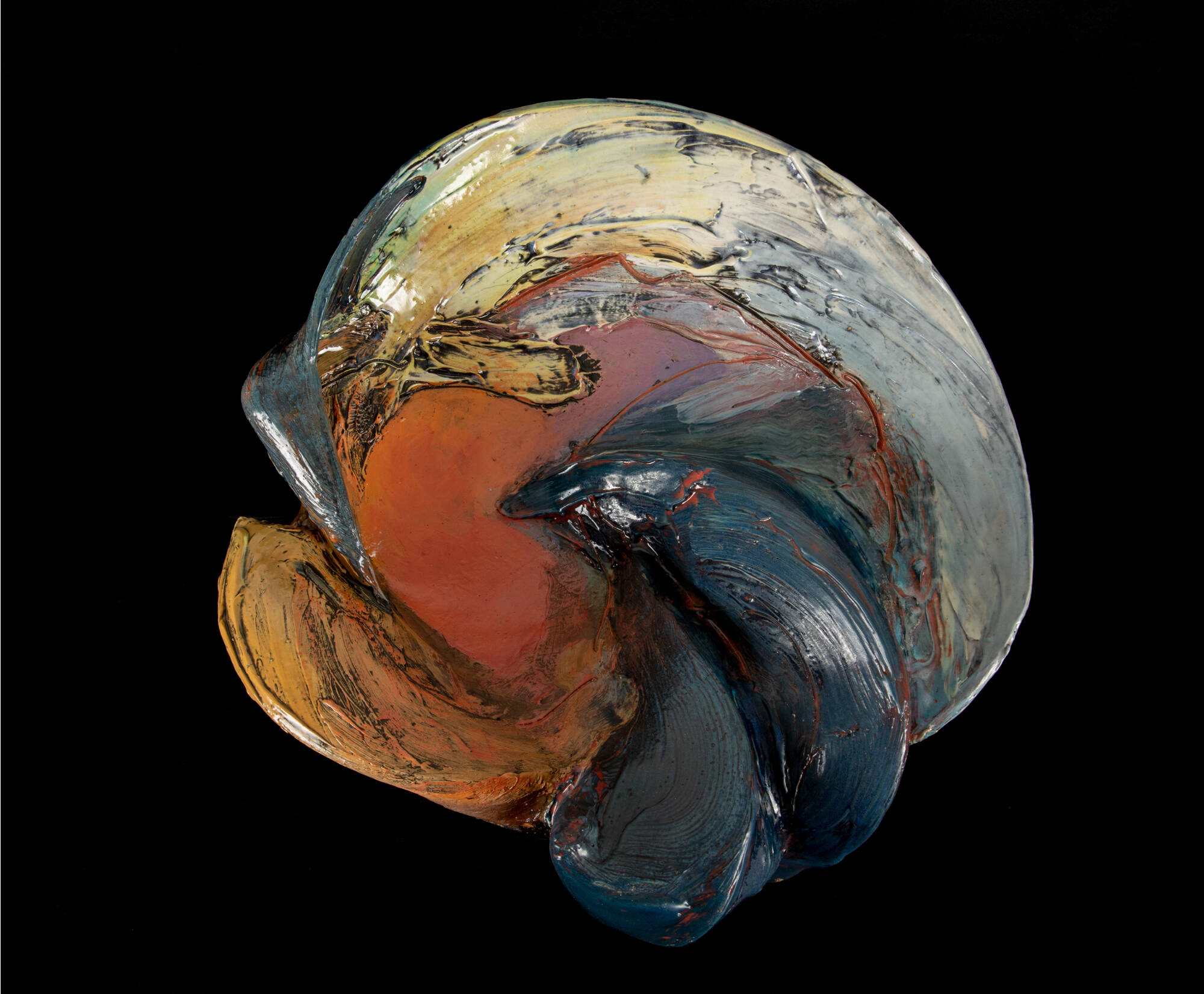 Wall hanging ceramic sculpture in the shape of a shell with curved layers. Dark glazes in shades of blue, orange, yellow, and grey.